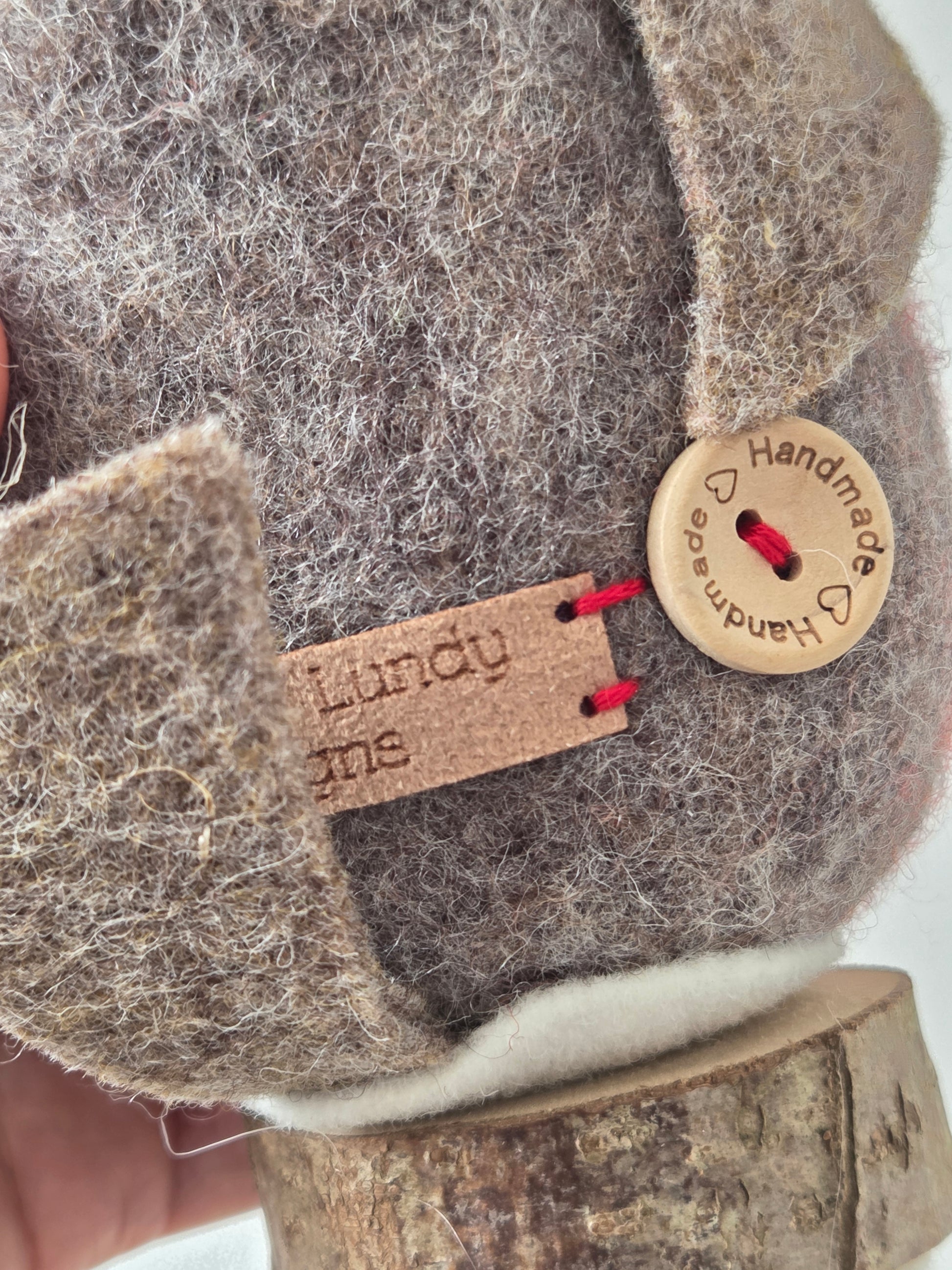 Close-up of a felted product with a 'Handmade' label and a tag with 'Lundy' branding.