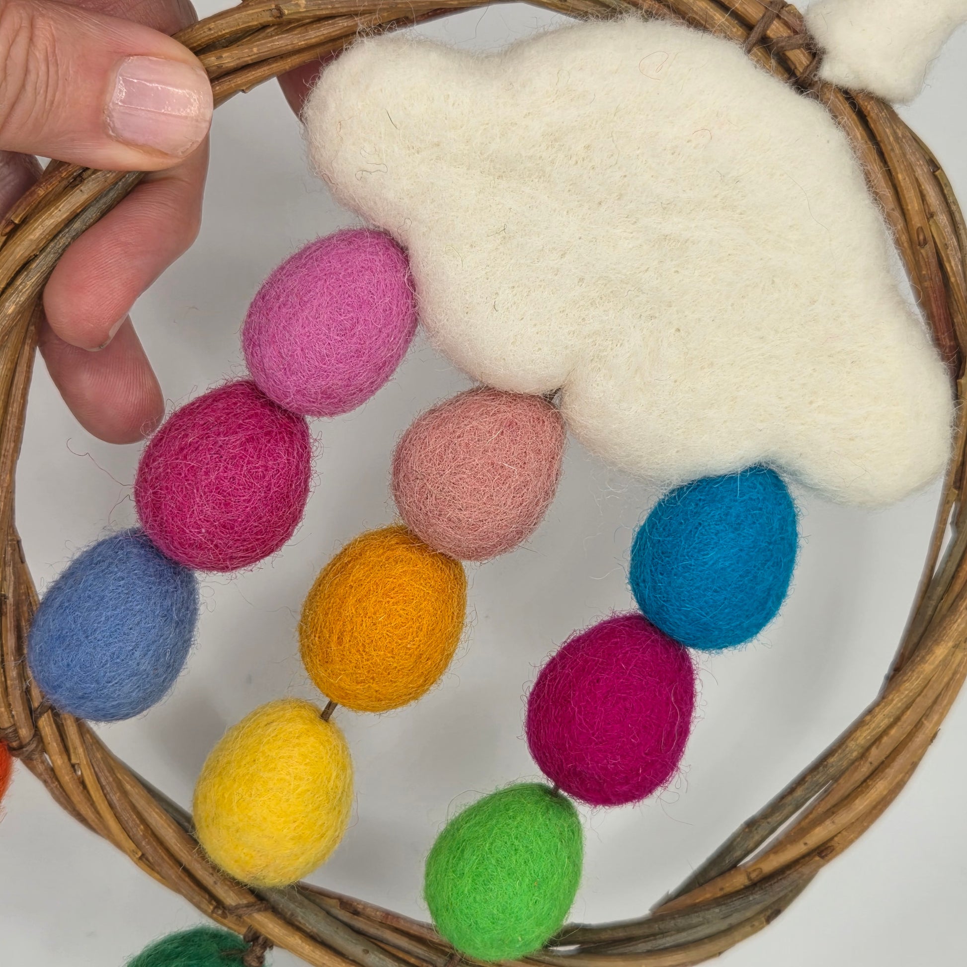 Decorative wreath with colorful felt balls and a cloud-shaped object.