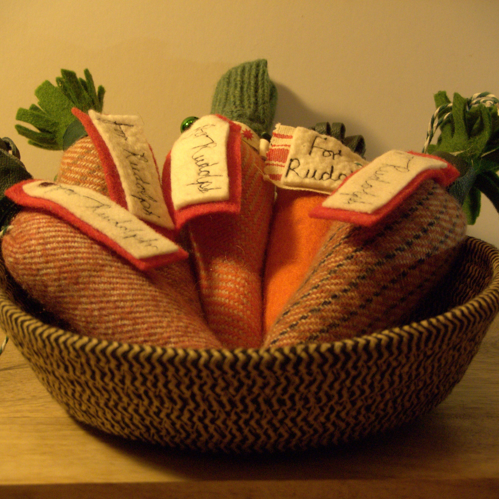 Decorative basket with toy vegetables on a wooden surface