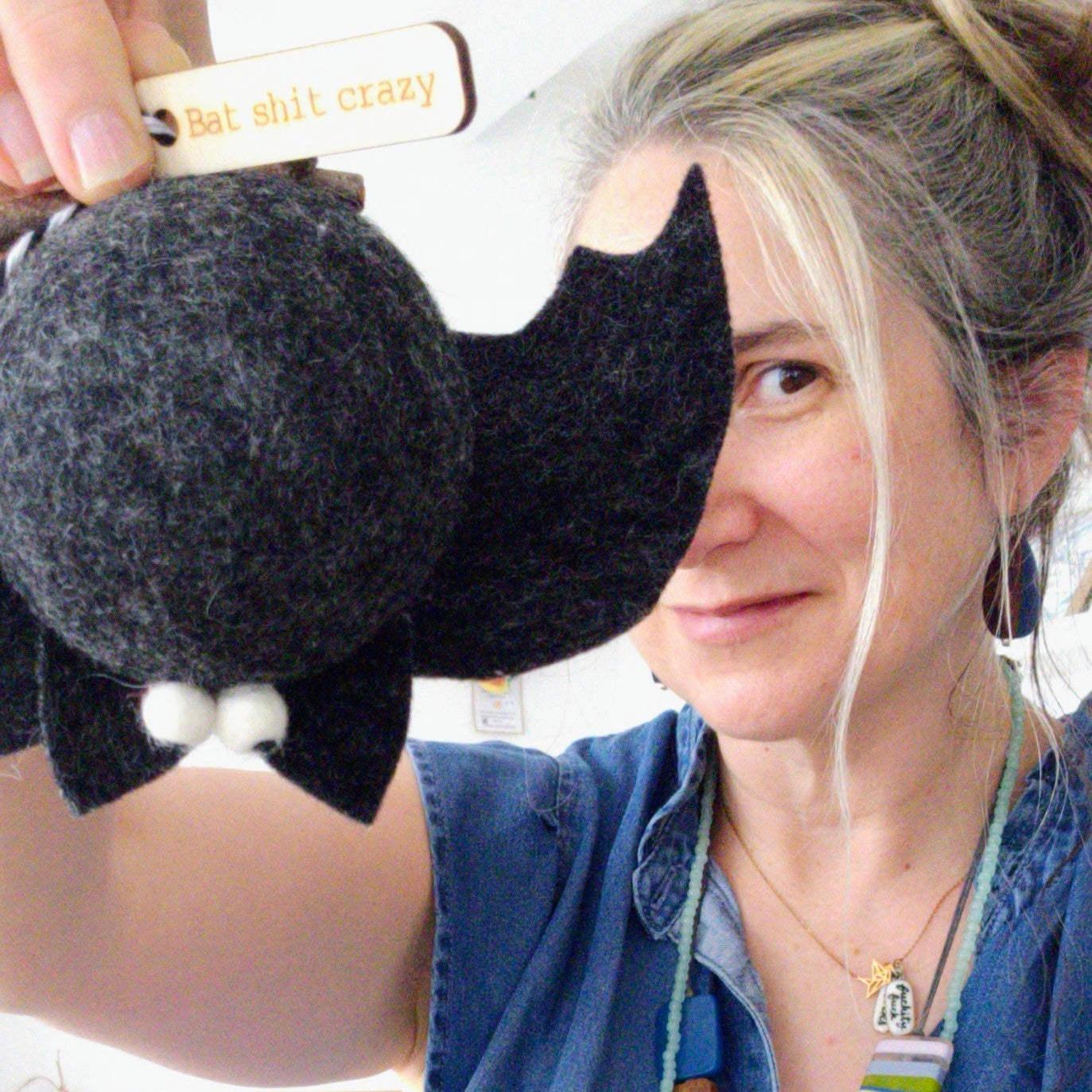 Person holding a black and gray felted product with a blurred background
