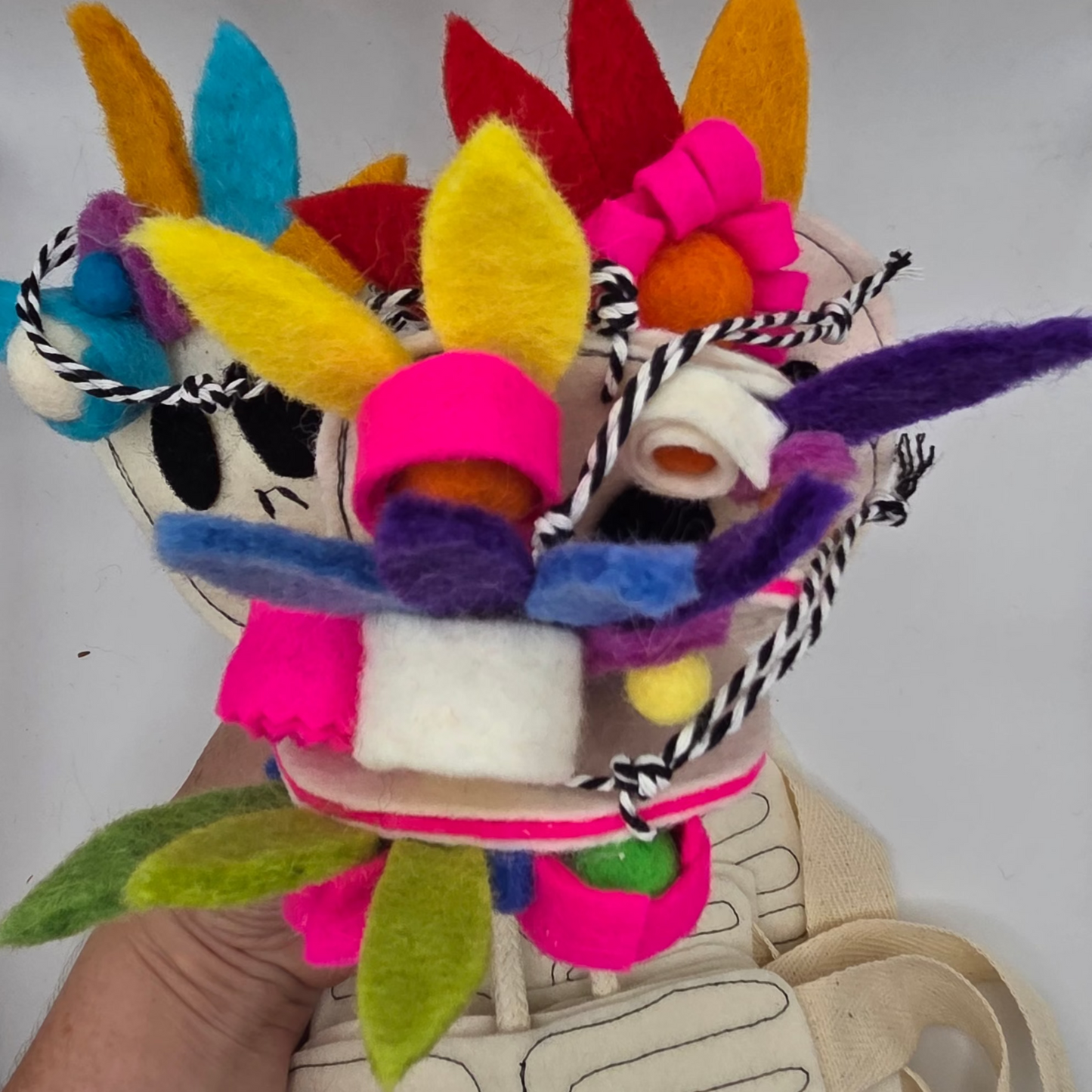 Colorful felt craft held by a hand