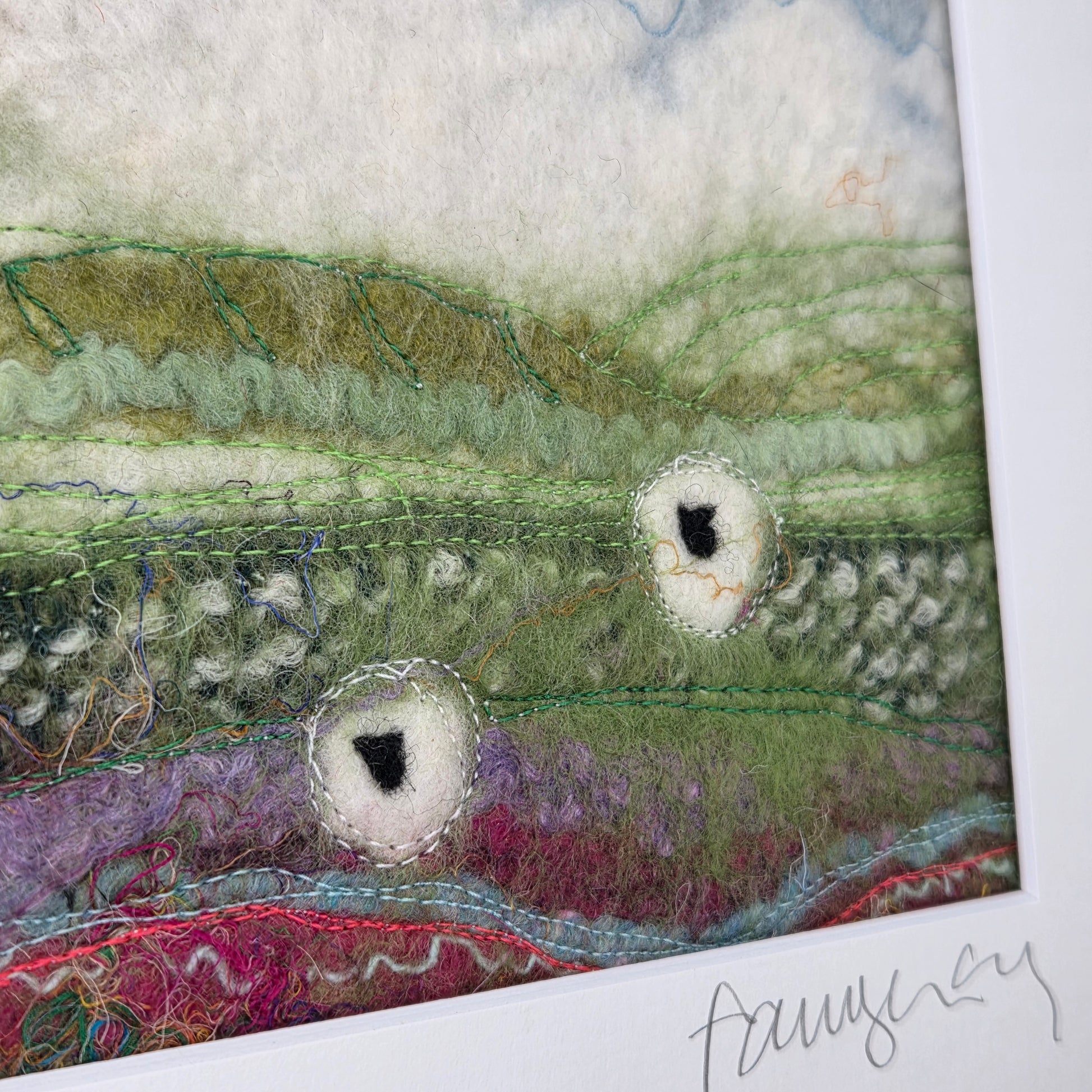 Textile art piece with organic patterns and textures on a white background