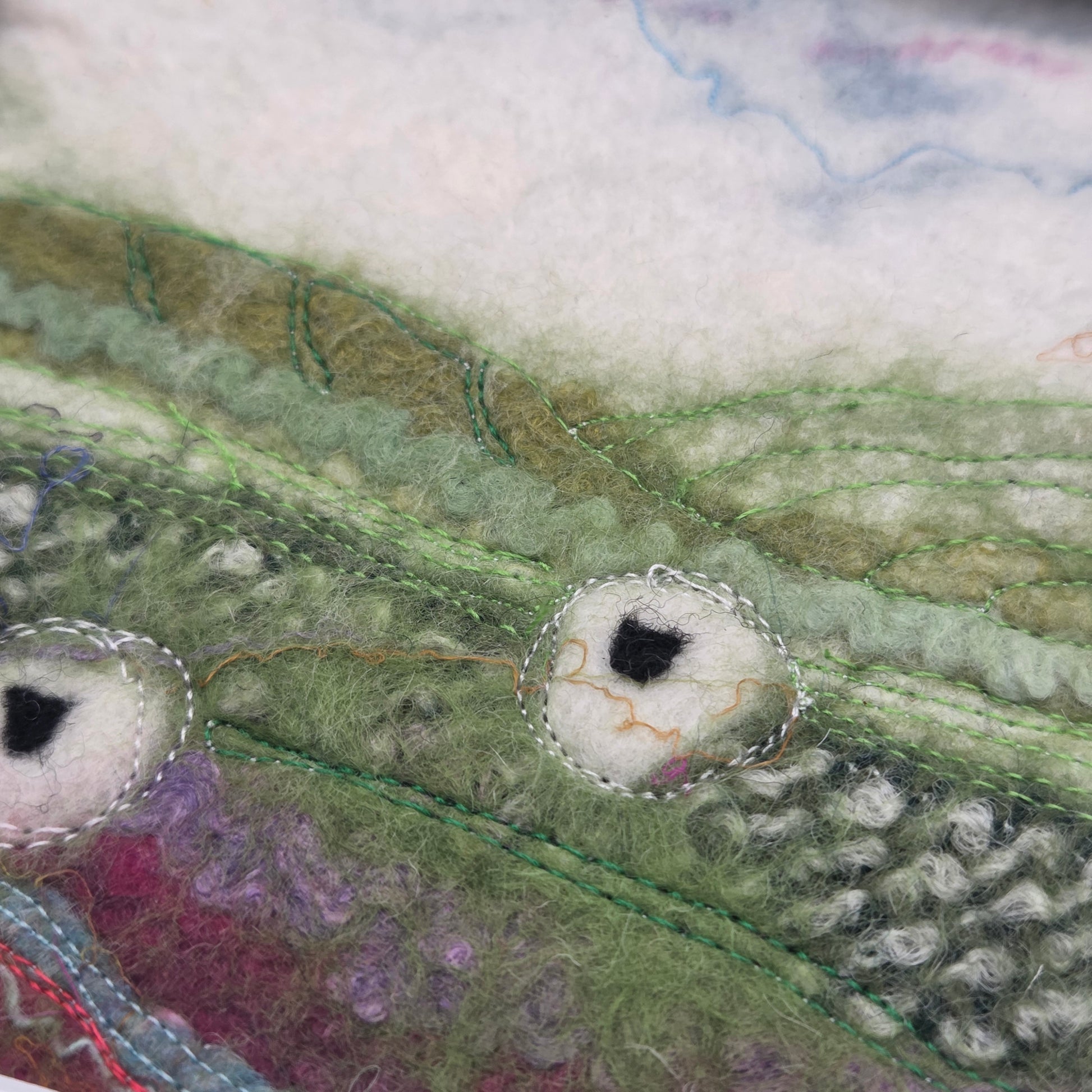 Close-up of textured fabric with green, purple, and white colors