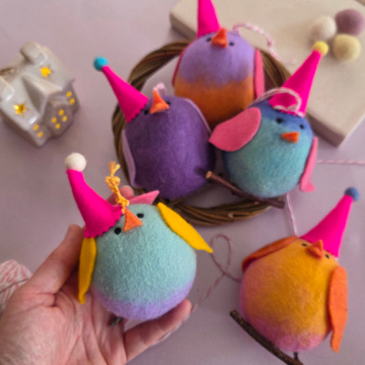 Colorful felt elf ornaments on a light background