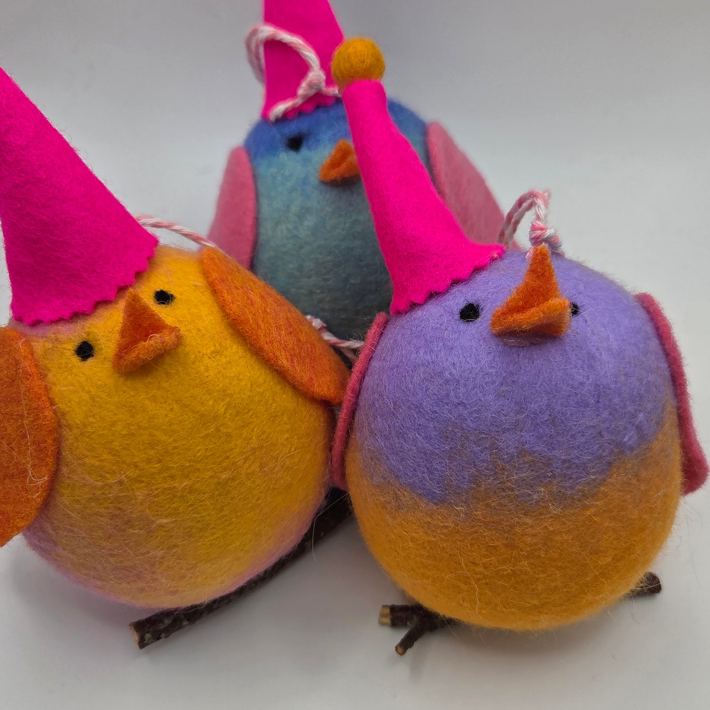 Colorful felt bird toys on a white background