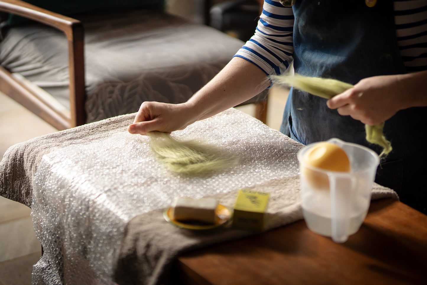 Person handling items on a table with bubble wrap, including a container of eggs and a box.