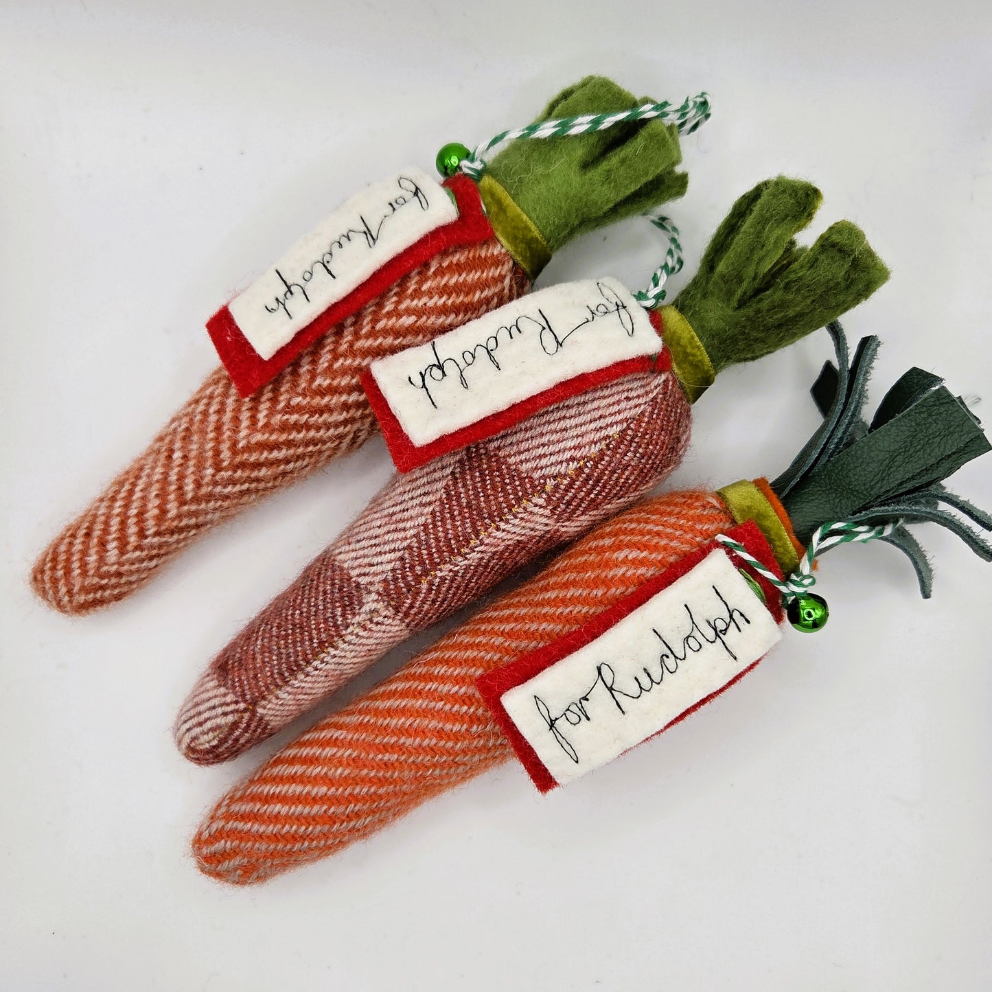 Three fabric carrots with labels on a white background