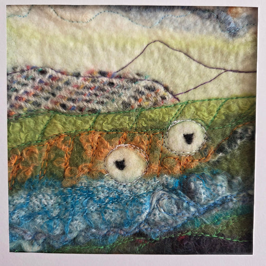 Textile art piece with multicolored patterns on a white background